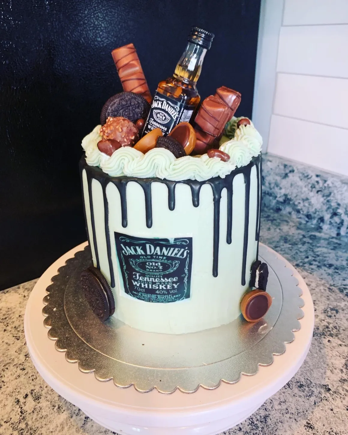Chocolate drip cake with candy and miniature bottle decoration